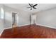 Spacious bedroom featuring hardwood floors, a ceiling fan, and two open doorways at 1130 Hardy Ave, Orlando, FL 32803