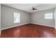 Empty bedroom with hardwood floors, a ceiling fan, and natural light from two windows at 1130 Hardy Ave, Orlando, FL 32803