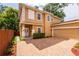 Two-story home with tan exterior, attached garage, and brick driveway at 1130 Hardy Ave, Orlando, FL 32803