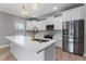 Bright kitchen with a center island, stainless steel refrigerator, and modern lighting fixtures at 1130 Hardy Ave, Orlando, FL 32803