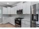Modern kitchen features white cabinets, stainless steel appliances, and elegant countertops at 1130 Hardy Ave, Orlando, FL 32803
