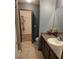 Well-lit bathroom with a granite counter, single sink vanity, and walk-in closet access for easy storage and functionality at 119 Stewart Lake Loop, Groveland, FL 34736