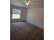 Spacious carpeted bedroom features a ceiling fan and large window, creating a bright and inviting atmosphere at 119 Stewart Lake Loop, Groveland, FL 34736