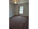 Cozy bedroom featuring carpet flooring, a window, a ceiling fan, and neutral wall color, creating a blank canvas at 119 Stewart Lake Loop, Groveland, FL 34736