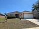Well-maintained single-story home with a two-car garage, landscaped yard, and neutral-toned exterior at 119 Stewart Lake Loop, Groveland, FL 34736