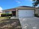 Charming single-story home featuring a well-manicured lawn and attached two car garage at 119 Stewart Lake Loop, Groveland, FL 34736