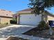 Two-car garage showcasing a driveway and modern exterior with plants at 119 Stewart Lake Loop, Groveland, FL 34736