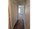 Hallway with a carpeted floor and a bedroom that is visible at the end of the hallway at 119 Stewart Lake Loop, Groveland, FL 34736
