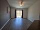Bright living room with vinyl flooring, large sliding glass doors, and stylish accent wall paint at 119 Stewart Lake Loop, Groveland, FL 34736