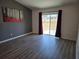 Bright living room with vinyl flooring, large sliding glass doors, and stylish accent wall paint at 119 Stewart Lake Loop, Groveland, FL 34736