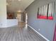 Open-concept living area with vaulted ceilings and light gray wood-look flooring throughout at 119 Stewart Lake Loop, Groveland, FL 34736