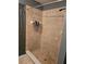 Bathroom shower with tan tile, a shower door and a neutral color scheme at 119 Stewart Lake Loop, Groveland, FL 34736