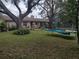 Large backyard with mature landscaping, patio, and a trampoline at 123 N High St, Lake Mary, FL 32746