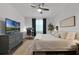 Relaxing bedroom with dark wood floors, a ceiling fan, and a flat-screen TV at 1232 Turnbridge Pl, Oviedo, FL 32765