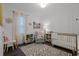 Bright Bedroom with a crib, accent wall, gray armchair, and decor at 1232 Turnbridge Pl, Oviedo, FL 32765