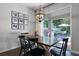 Dining room with a wooden table, black chairs, modern chandelier, and sliding doors to the backyard at 1232 Turnbridge Pl, Oviedo, FL 32765