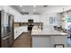 Well-lit kitchen featuring stainless steel appliances, white cabinets, granite countertops and adjacent dining space at 1232 Turnbridge Pl, Oviedo, FL 32765
