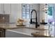 Modern kitchen featuring granite countertops, a farmhouse sink, and a stylish black faucet at 1232 Turnbridge Pl, Oviedo, FL 32765