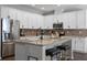 Stylish kitchen featuring white cabinetry, granite countertops, a brick backsplash, and stainless steel appliances at 1232 Turnbridge Pl, Oviedo, FL 32765
