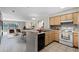 Bright kitchen with light wood cabinets, a black dishwasher and white appliances open to a dining and living area at 13839 Fairway Island Dr # 1116, Orlando, FL 32837
