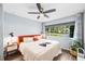 Well-lit bedroom with a large window, ceiling fan, and neutral color palette at 1421 N Hampton Ave, Orlando, FL 32803