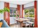 Bright dining room with modern seating, wood table, gray shades, and orange drapes at 1421 N Hampton Ave, Orlando, FL 32803