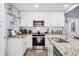 Modern kitchen with white cabinets, granite countertops, and stainless steel appliances at 1421 N Hampton Ave, Orlando, FL 32803