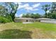 Expansive backyard with mature trees, concrete patio, and space for outdoor activities at 14878 Se 32Nd Ter, Summerfield, FL 34491
