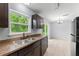 Bright kitchen featuring modern appliances, dark cabinets, and a garden view at 14878 Se 32Nd Ter, Summerfield, FL 34491