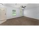 Spacious living room featuring plush carpet flooring, a ceiling fan, and bright windows at 14878 Se 32Nd Ter, Summerfield, FL 34491