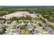 Aerial view of houses in a neighborhood with trees, ponds, and a construction zone in the background at 15242 Heron Hideaway Cir, Winter Garden, FL 34787