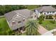 Aerial view of a tan house with red shutters, brick driveway, and a well-maintained lawn at 15242 Heron Hideaway Cir, Winter Garden, FL 34787