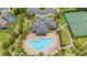 A top-down view of the community pool and tennis courts with surrounding greenery at 15242 Heron Hideaway Cir, Winter Garden, FL 34787