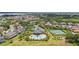 Aerial view of a community with a pool, a tennis court, ponds, and mature trees at 15242 Heron Hideaway Cir, Winter Garden, FL 34787