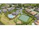 Aerial view of a community with a pool, a tennis court, ponds, and mature trees at 15242 Heron Hideaway Cir, Winter Garden, FL 34787