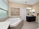 Bright bathroom featuring a soaking tub and a granite-topped vanity at 15242 Heron Hideaway Cir, Winter Garden, FL 34787