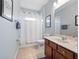 Bright bathroom featuring a single vanity, framed mirror, tiled flooring, and shower with curtain at 15242 Heron Hideaway Cir, Winter Garden, FL 34787