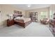 Primary bedroom featuring dark wood furniture, soft carpeting, and a bright window providing natural light at 15242 Heron Hideaway Cir, Winter Garden, FL 34787