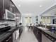 Well-lit kitchen with dark cabinets, granite countertops, stainless steel appliances, and tile backsplash at 15242 Heron Hideaway Cir, Winter Garden, FL 34787