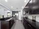 Spacious kitchen with dark cabinetry, granite countertops, stainless steel appliances, and tiled backsplash at 15242 Heron Hideaway Cir, Winter Garden, FL 34787
