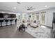 Bright living room with tile floors, neutral-colored sectional sofa, and large windows overlooking the backyard at 15242 Heron Hideaway Cir, Winter Garden, FL 34787