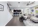 Open-concept living area with modern sectional, breakfast bar, and gray flooring, perfect for entertaining at 15242 Heron Hideaway Cir, Winter Garden, FL 34787