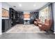 Well-lit office space with built-in bookshelves, a large rug, and two comfortable armchairs at 15242 Heron Hideaway Cir, Winter Garden, FL 34787