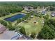 Aerial view of a community park with a pond, playground, and walking paths, perfect for outdoor activities at 15443 Sugarcup Ct, Orlando, FL 32828