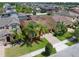 Aerial view of a home with manicured lawn, palm trees, and brick driveway at 15443 Sugarcup Ct, Orlando, FL 32828
