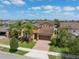 An aerial view shows a well-maintained home with a lawn, palm trees, and a driveway at 15443 Sugarcup Ct, Orlando, FL 32828