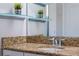 Close-up of the bathroom vanity with granite countertops and decorative shelves at 15443 Sugarcup Ct, Orlando, FL 32828