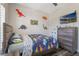 Comfortable bedroom featuring a dinosaur theme, a ceiling fan, and a dresser at 15443 Sugarcup Ct, Orlando, FL 32828