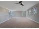Bright carpeted room features a ceiling fan and three windows at 15443 Sugarcup Ct, Orlando, FL 32828
