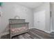 Bedroom with hardwood floors, a gray crib, and pastel decals at 15443 Sugarcup Ct, Orlando, FL 32828
